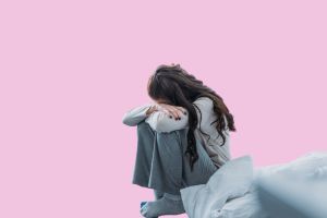 膝を抱えて座り込む女性の姿。婚活がうまくいかず、落ち込んでいる様子を連想させるシーン