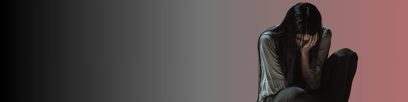 頭を抱えて悩む女性。離婚や婚活がうまくいかず落ち込んでいる様子